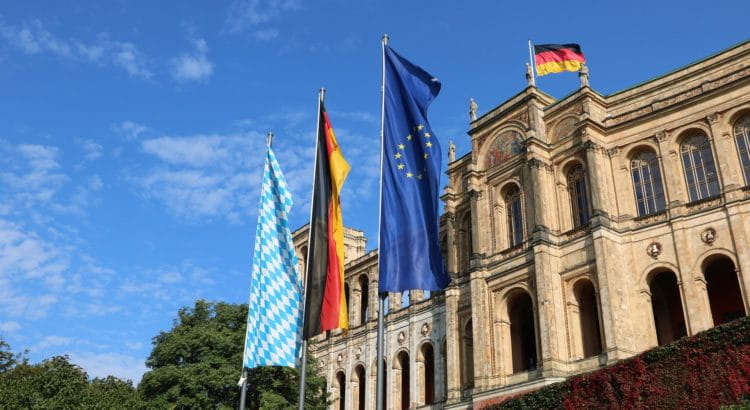 Maximilianeum in Bayern; davor drei Flaggen: Europa, Österreich, Bayern.